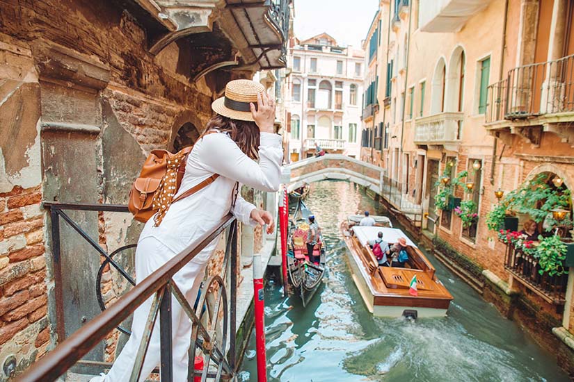 image Italie Venise Femme regardant le canal avec une gondole as_284877676