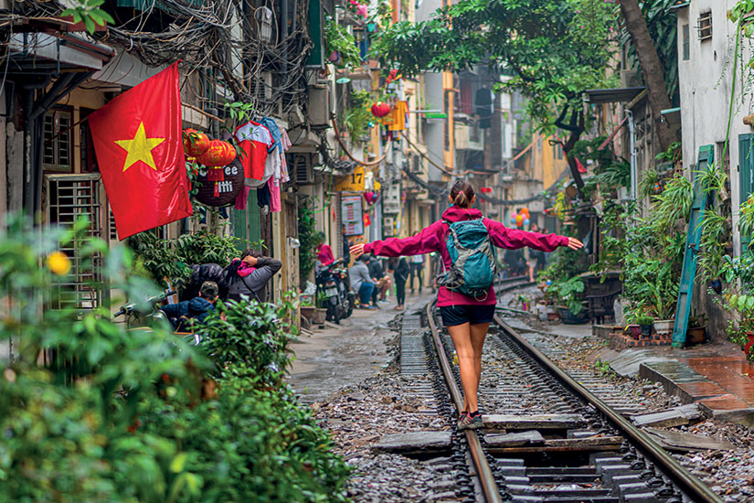 https://images.salaun-holidays.com//-image-Vietnam-Hanoi-femme-marchant-sur-la-voie-ferree-as_301850451.jpg