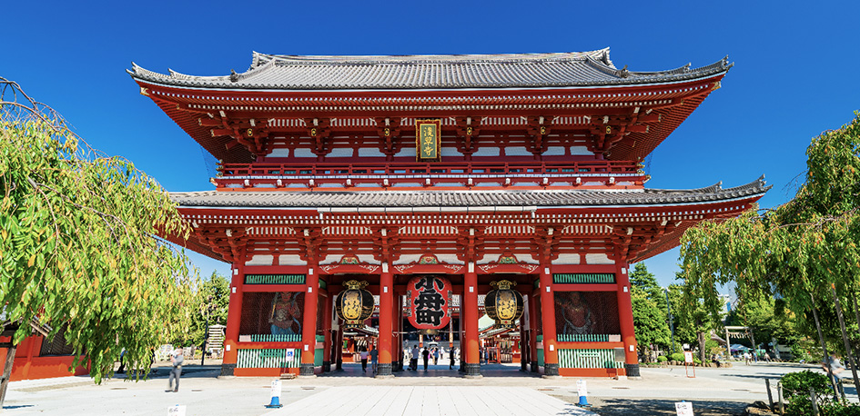 Porte rouge du temple bouddhiste de Sensō-ji à Tokyo avec ses statues et lanternes traditionnelles.