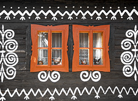 Fenêtre rouge et devanture de maison en bois peinte du village de Čičmany en Slovaquie