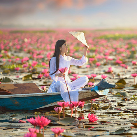 Femme en habits traditionnels assise sur une barque
