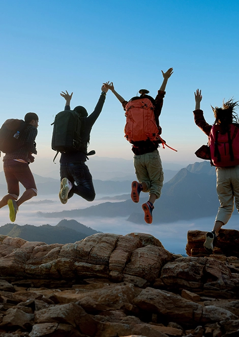 4 voyageurs sautant de joie sur une montagne