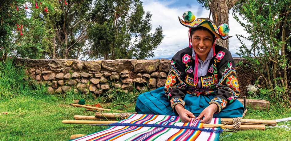 Femme du Pérou en tenue traditionnelle tissant de la laine d'alpaga