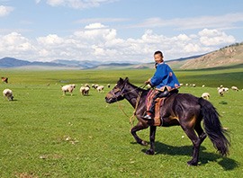 Une jeune mongol à cheval dans les steppes